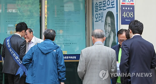 금융위원회가 4개 저축은행을 부실 금융기관으로 결정하고 영업정지와 경영개선명령을 내린 가운데 7일 오전 영업이 정지된 서울 강남구 대치동 솔로몬저축은행 본점 앞에서 직원들이 불안해하는 고객들에게 예금자설명회에 대해 안내하고 있다.
